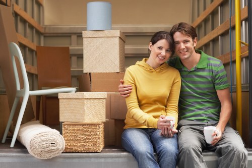 Movers carrying furniture through a Hackney flat entrance